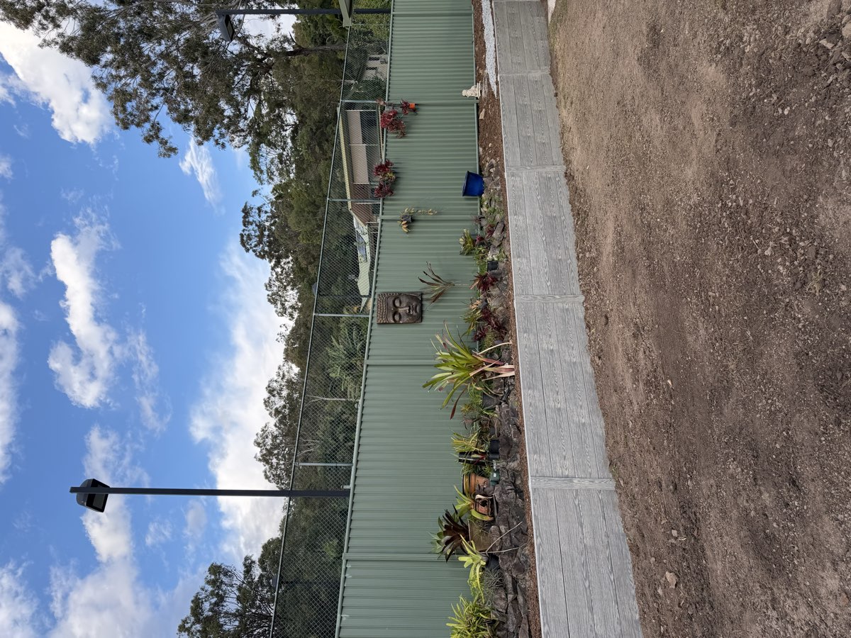 Finished retaining wall with established garden and new fence